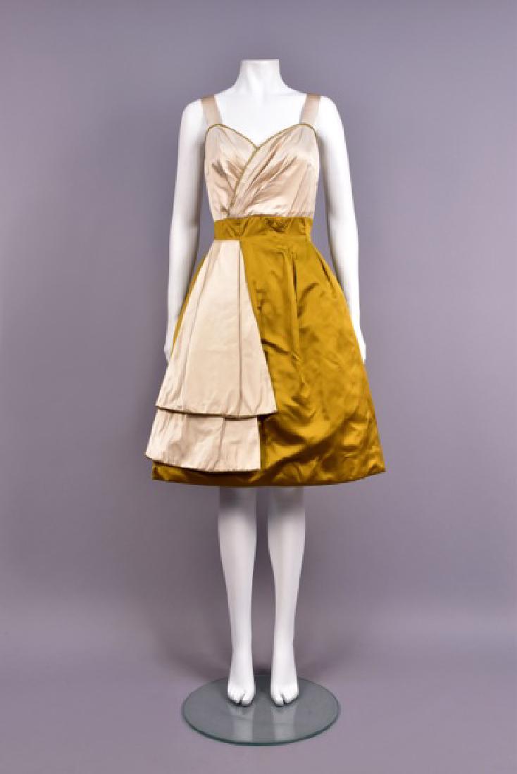JEAN MARCHAND SILK COCKTAIL DRESS, 1950s: Ivory satin surplice high-waist bodice with sweetheart neckline edged in tiny beads having wide strap, gold satin skirt with inverted pleats stitched down to the waist having flared ivory drape to one