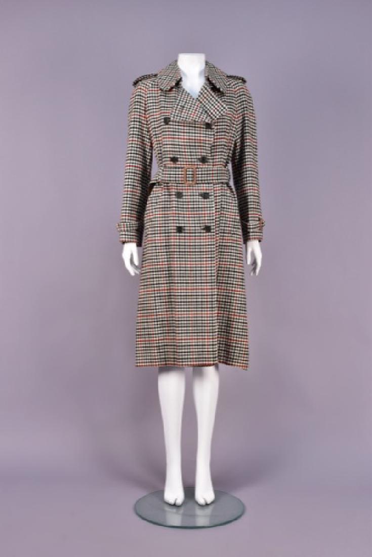 LADYS BURBERRYS CLASSIC PLAID TRENCH COAT, 1970s.: Double-breasted cream wool woven with polychrome windowpane pattern, having belted raglan sleeve, epaulets, oblique pockets and wide belt. Labeled. B-38, L-45. (One button detached but retained) excel