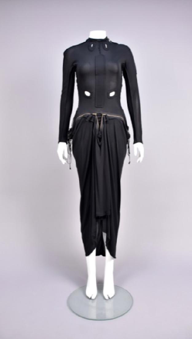 GAULTIER KNIT BONDAGE DRESS: Long sleeve black rayon jersey having welted cutouts, zipper details and side laces, fitted to the waist, full skirt cinched around front zipper with high-low hem. Labeled. Unstretched B-32, W-24, L-5