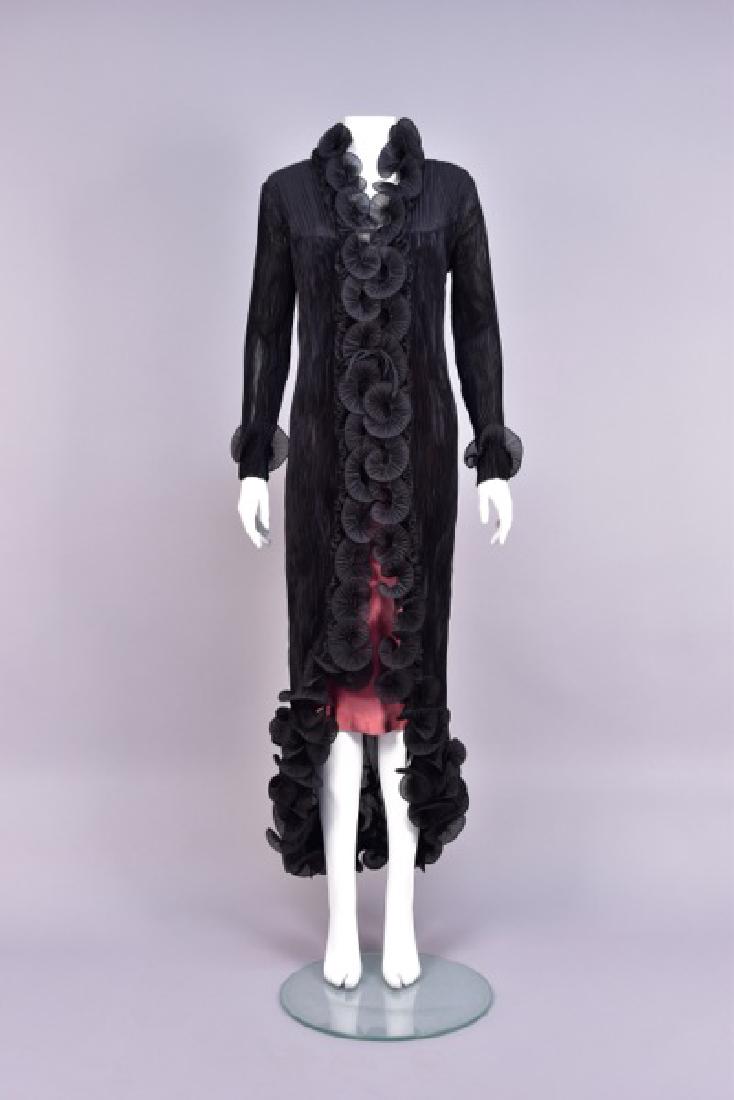 JOAN McGEE ARTISAN PLEATED EVENING COAT: Black with Fortuny-style pleats, the long sleeve wired at the cuff, cutaway front edges and gored hem decorated with wired pleats over self ruffles. Labeled. Unstretched B-38, L-56. Excellent.