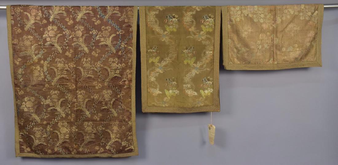 THREE RUSSIAN SILK BROCADE TABLE RUNNERS, 18th C: All different pattern silk and metallic brocades in earth tones with floral sprays all trimmed in gold galloon. Largest 80 x 32. Very good. ALVR.