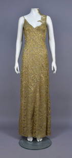 ANGEL SANCHEZ GOLD LACE GOWN: Sleeveless metallic gold lace over grey and nude chiffon layers, having spaghetti strap, decorated on one shoulder with lace ruffle, deep V back with self buttons, the chiffon with bands of large rhin