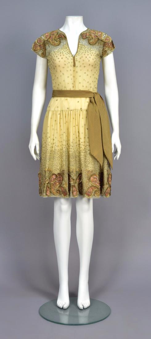 BILL BLASS APPLIQUED and EMBROIDERED COCKTAIL DRESS: Cream net over ivory chiffon having metallic gold embroidery and appliquÃ©d with brown suede botehs with silk embroidery and silver sequins, cap sleeve, sheer bodice top, V-neck bound in striped sil