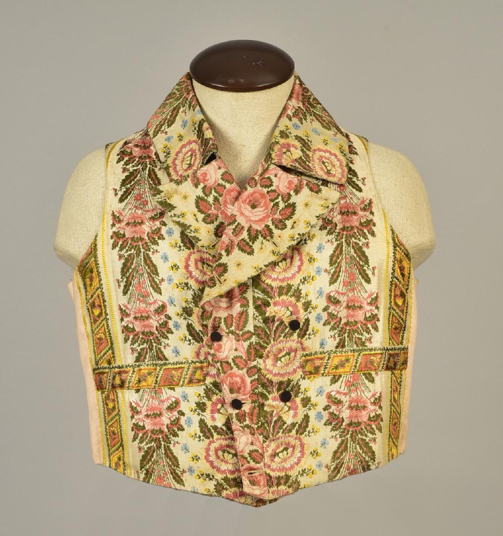 GENTLEMAN'S SILK BROCADE WAISTCOAT, 1810: Cream silk twill with a polychrome floral brocade stripe having narrow double breast, fold-down collar and wide lapel, black wool-covered buttons, straight pockets, cotton back and lining. Lot 37 Chri