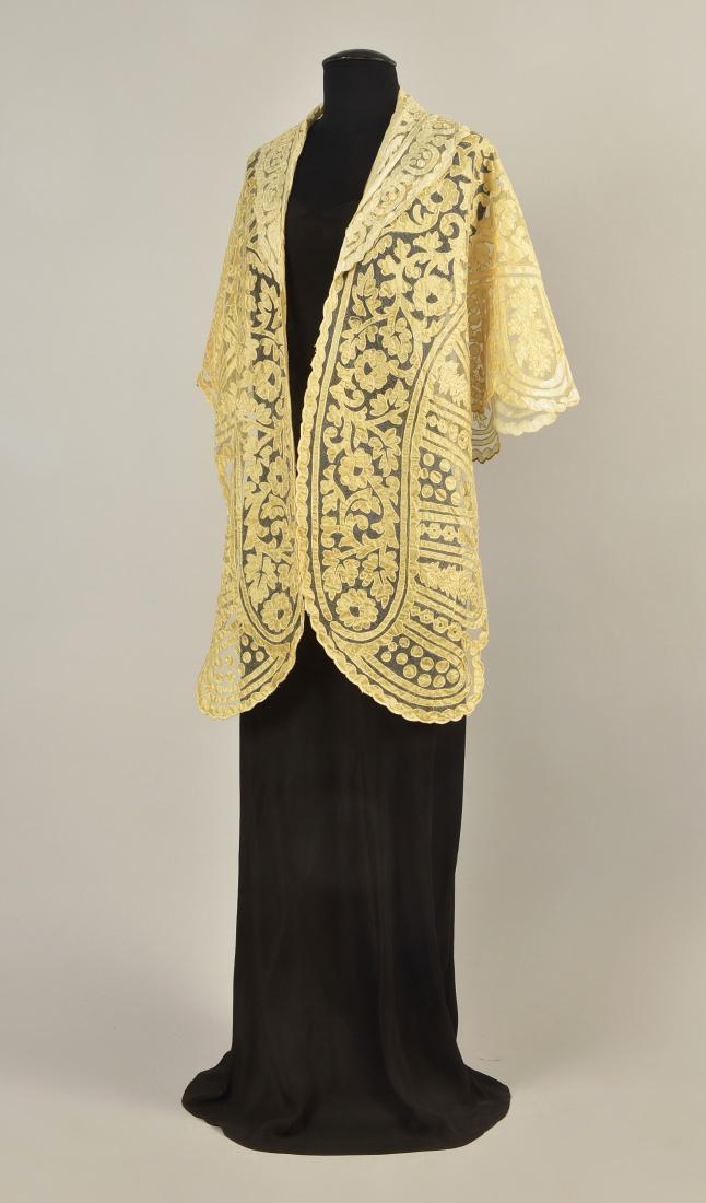 SILK APPLIQUE NET MANTLE, 1850s: Ivory taffeta on silk net shaped triangle with collar having a stylized floral and scalloped borders with dot and arch motif. 21 x 74. (Few small stains) very good.