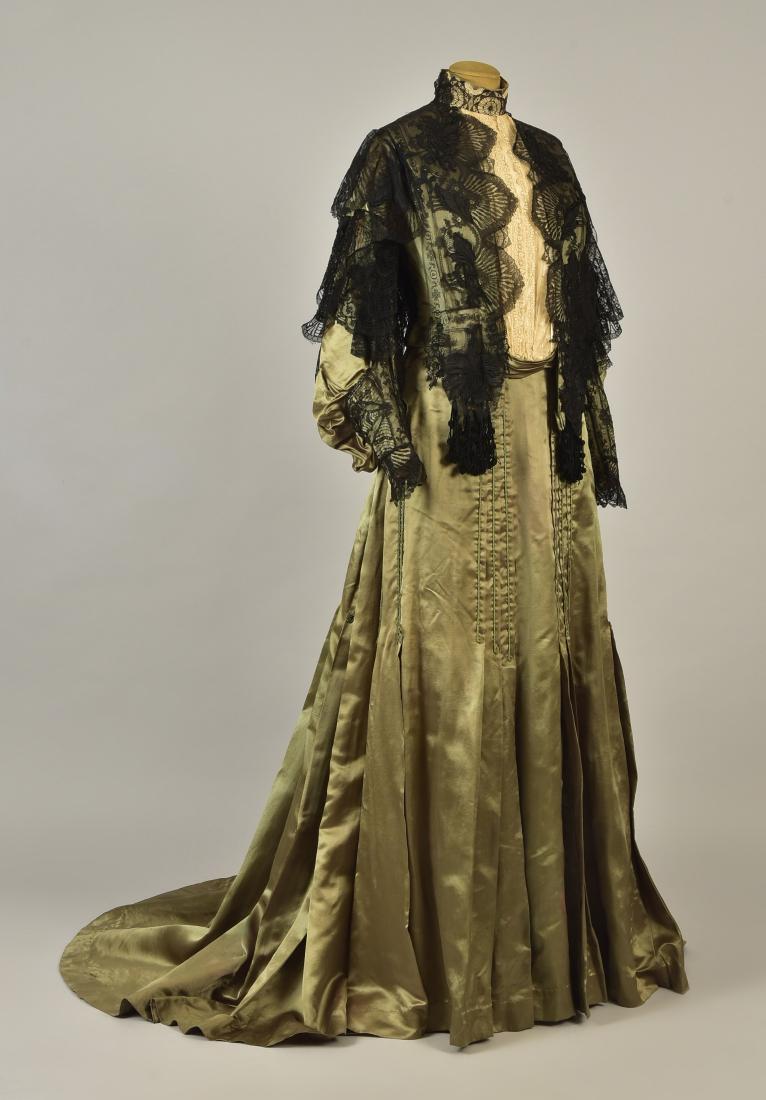 LACE over SATIN GOWN with ROYAL PROVENANCE, 1903: Two-piece olive green silk, boned high-neck bodice having long, full sleeve gathered into cuff, bodice overlay of black lace with an insert of cream embroidered net, back trimmed with olive cording ov