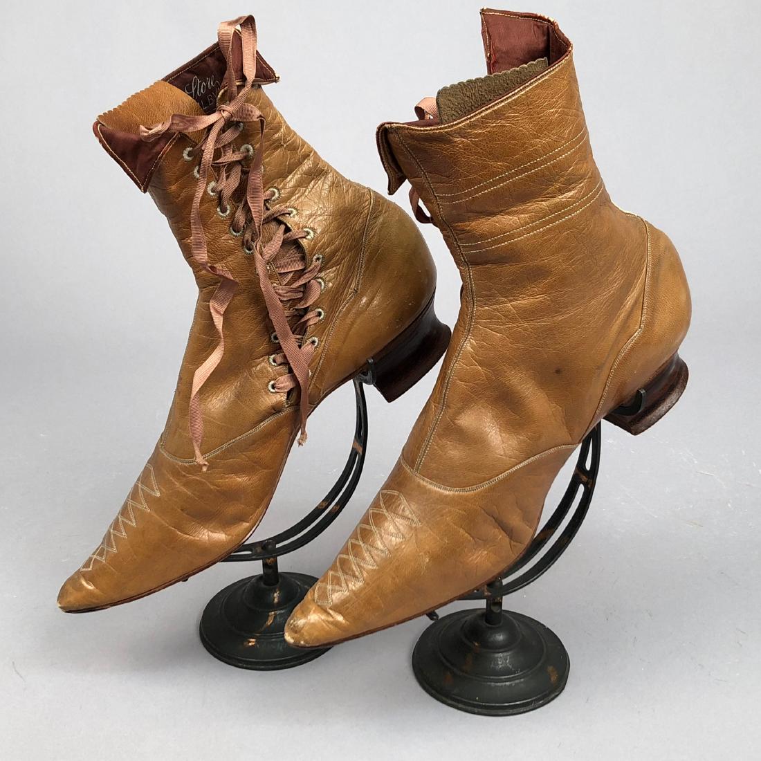 LADY'S SIDE-LACING BOOTS with TOPSTITCHING, 1890s: Tan glazed leather with foldover top, pointed toe topstitched in a series of diamonds, side lacing with grosgrain ribbon, stacked wood heel, silk facing, twill lining. Label "New York Store, Trilby, I