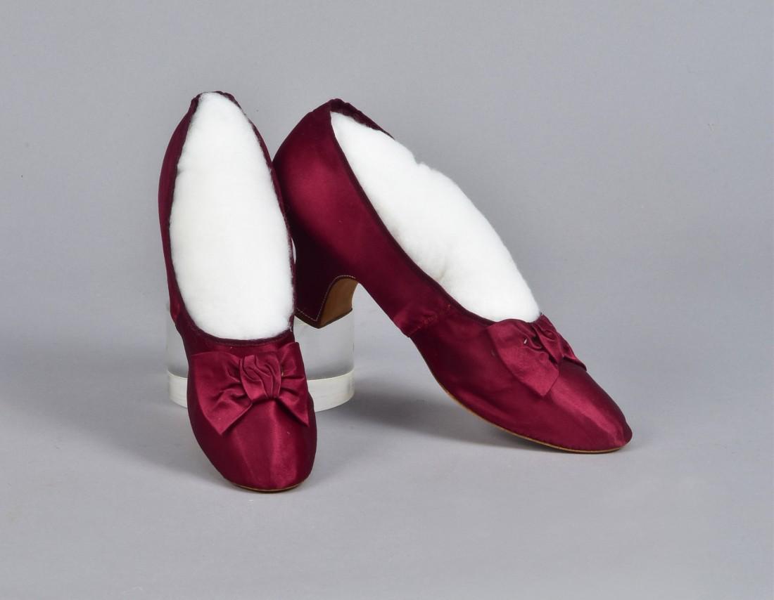 FRENCH SILK SHOES with BOW, c. 1890: Red-violet satin having a rounded toe, white topstitching to Louis heel, self bow at vamp, partial kid lining and insole, label "Meier". 2 1/2 x 10 with 2-inch heel. (Bows partially unstitched) otherw