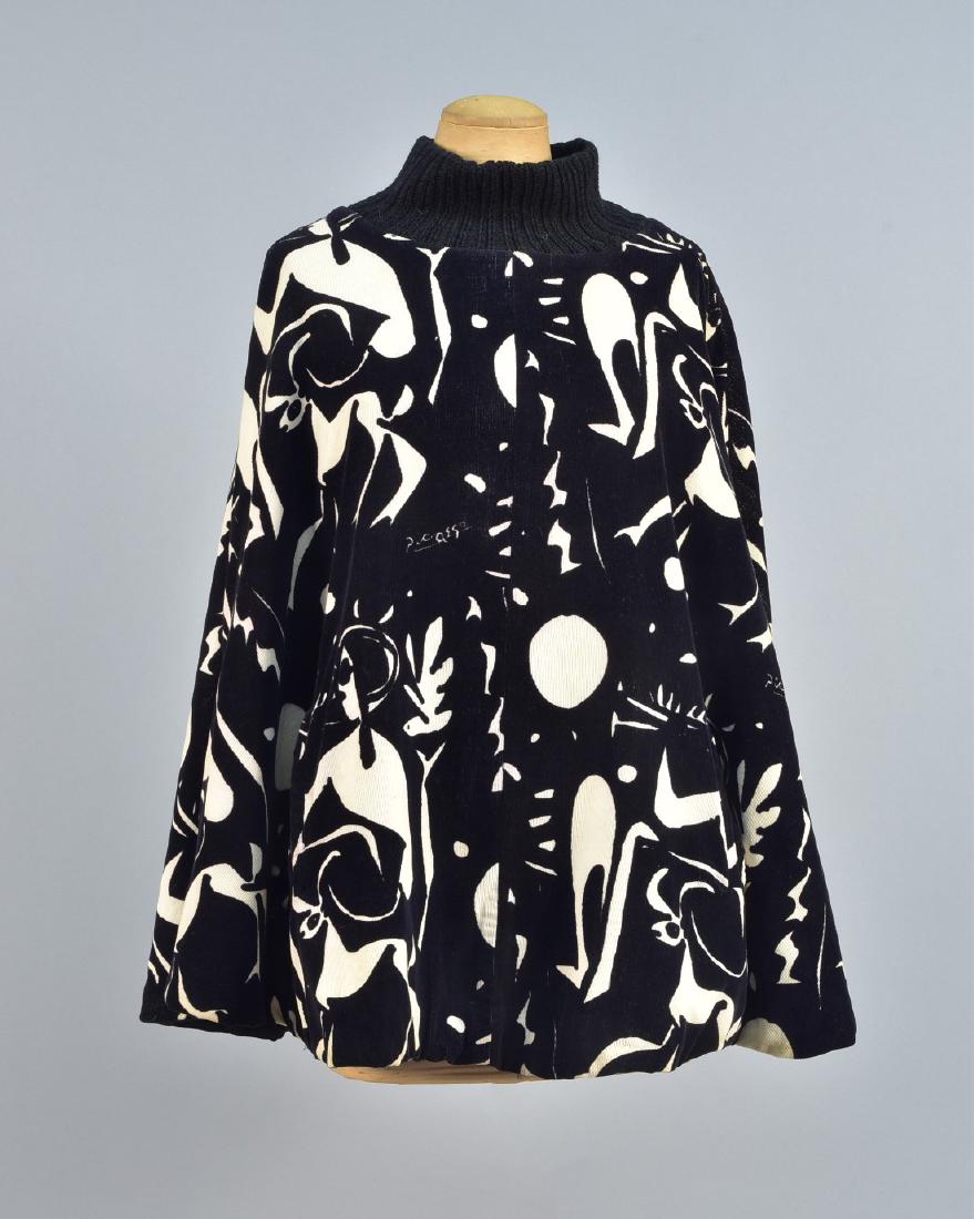 WHITE STAG PICASSO DESIGN CAPE, 1963: Black and white cotton corduroy with repeating Picasso design, knitted black collar, vertical welt pockets, quilted lining, labeled. L-29. (Light soil and small spots, some black dye losses) good.