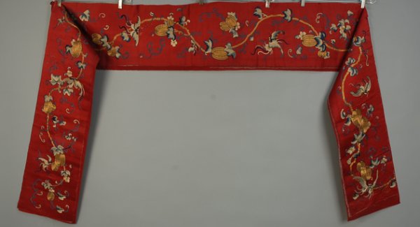CHINESE RED SILK SATIN WIDE BORDER, LATE 19th C Ha: CHINESE RED SILK SATIN WIDE BORDER, LATE 19th C Having silk embroidered bats and gold couched fruit. 11 1/2 x 133. Some worn areas and broken metallic threads, fair.