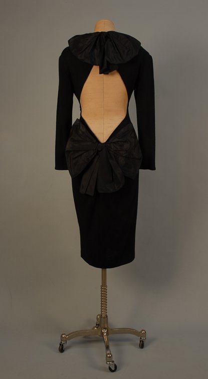 ANGELO TARLAZZI, PARIS, COCKTAIL DRESS, LATE 20th : ANGELO TARLAZZI, PARIS, COCKTAIL DRESS, LATE 20th C Black knit with large satin bow at back of neck and below the low back cutout, long sleeve, narrow skirt. Bust 34, waist 26, hip 36, sleeve 21, leng
