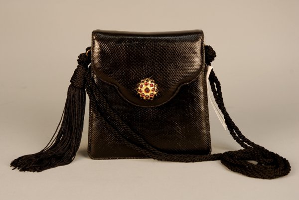 JUDITH LEIBER DEADSTOCK LIZARD EVENING BAG, LATE 2: JUDITH LEIBER DEADSTOCK LIZARD EVENING BAG, LATE 20th C Black trapezoid with scalloped flap, braided cord strap with tassel, brass hardware, jeweled clasp. 6 x 6 with 20 inch strap. Pristine.