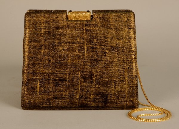 JUDITH LEIBER DEADSTOCK EVENING BAG, LATE 20th C B: JUDITH LEIBER DEADSTOCK EVENING BAG, LATE 20th C Black and gold silk with jeweled clasp and brass chain, hinged frame, three interior compartments, two inside pockets 5 3/4 x 6 3/4 with 20 inch chain.