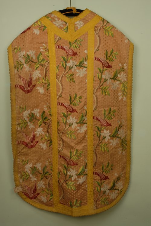 SILK BROCADE CHASUBLE, 18th C. Flesh figured ground: SILK BROCADE CHASUBLE, 18th C. Flesh figured ground having brocade red and pink birds on branchwork with white blossoms, gold metallic trim. 31 x 46. Few broken threads, excellent.