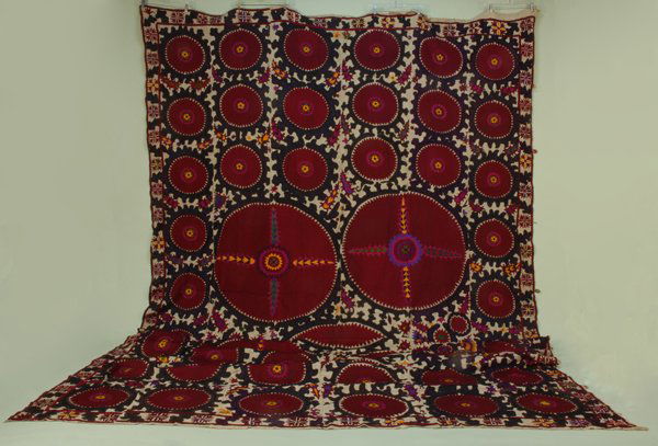 TASHKENT SUSANI, 20th C. Natural cotton decorated w: TASHKENT SUSANI, 20th C. Natural cotton decorated with silk in cranberry with purple, pink, gold, green and blue, 101 x 180. Cotton ground has few minor stains, excellent.