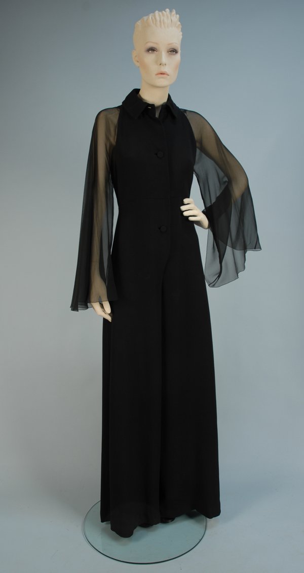 GALANOS BLACK SILK CREPE and CHIFFON JUMPSUIT, 197: GALANOS BLACK SILK CREPE and CHIFFON JUMPSUIT, 1970's. Wide leg, front opening with two self fabric buttons and six snaps, crepe armhole cut toward collar, full chiffon bell sleeve, side slit pockets,