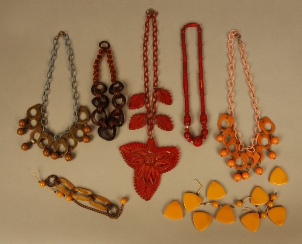 LARGE CHERRY JELLO BAKELITE NECKLACE, 1920's-1940': LARGE CHERRY JELLO BAKELITE NECKLACE, 1920's-1940's. Translucent cherry red large trefoil leaf form pendant with carved flower, four smaller leaf drops on link chain. Together with four smaller neckla