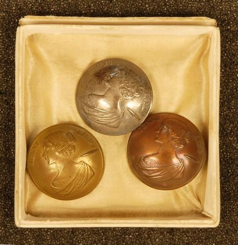 RARE JENNY LIND BUTTON SET. Three medium convex 1-piece: RARE JENNY LIND BUTTON SET. Three medium convex 1-piece buttons with portrait bust in low relief profile and "Jenny Lind" across top, in three finishes: silvered, brass and copper. 1 1/8 inches. With 