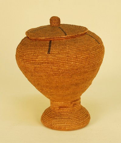 NATIVE AMERICAN ESKIMO INUIT COVERED BASKETRY JAR, c. 1: NATIVE AMERICAN ESKIMO INUIT COVERED BASKETRY JAR, c. 1900. Pedestal form covered basket with seal gut decoration of radiating lines. 7 1/2 x 11. Excellent.