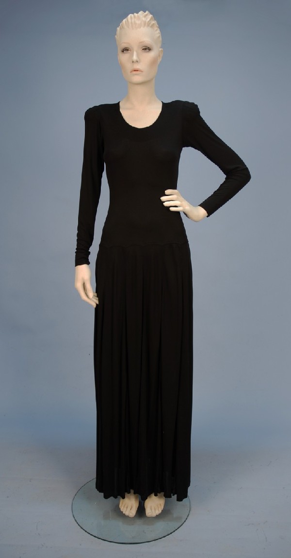 JEAN MUIR BLACK RAYON JERSEY KNIT LONG DRESS, 198: JEAN MUIR BLACK RAYON JERSEY KNIT LONG DRESS, 1980's. Long narrow sleeve with button and loop at wrist, U-neck, slightly padded shoulder with tucks, dropped waist, full skirt with side slit pockets, b