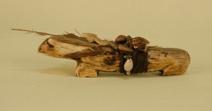 NATIVE AMERICAN CARVED FETISH, 1900-1930. Probably: NATIVE AMERICAN CARVED FETISH, 1900-1930. Probably Zuni, antler or bone in the form of a bear, having a carved lightning bolt with arrow head wrapped with hide strips to its back, along with shells, s