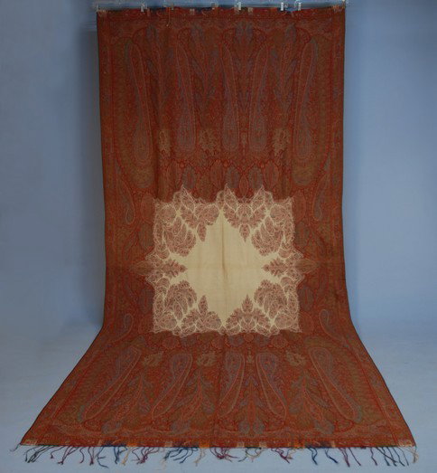 WOOL PAISLEY SHAWL, 19th C. Long shawl having eigh: WOOL PAISLEY SHAWL, 19th C. Long shawl having eight pointed square cream center, the decoration carrying over into the field. 140 x 66. (Few scattered holes) good.