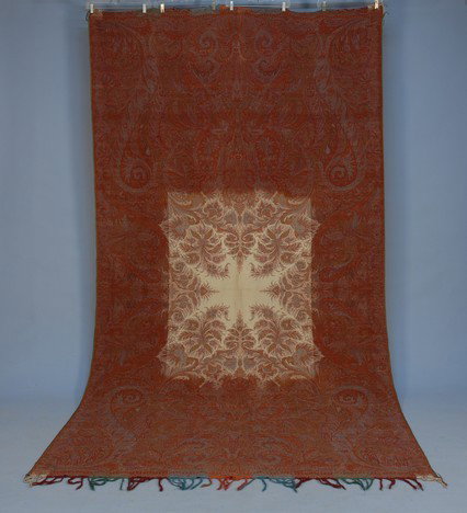 WOOL PAISLEY SHAWL, 19th C. Long rectangle having : WOOL PAISLEY SHAWL, 19th C. Long rectangle having a rectangular white field with star. 54 X 123. Very minor holes, sewn edge tape on long border) overall excellent.