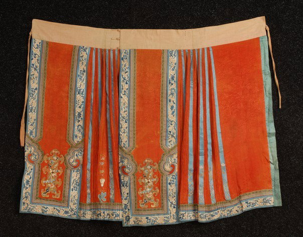 CHINESE SILK EMBROIDERED SKIRT, 19th C. Pleated re: CHINESE SILK EMBROIDERED SKIRT, 19th C. Pleated red brocade with satin stitch embroidery and heavy couched gold appliques with figures, (minor stains) good. Together with a red silk satin skirt with f