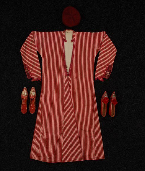TURKISH SILK COAT with TWO PAIR SHOES, 19th C. Coa: TURKISH SILK COAT with TWO PAIR SHOES, 19th C. Coat with red and white woven stripe, lower sleeve lined with purple printed cotton paisley, looped red braid trim and closures, linen lining, 64 x 51. T