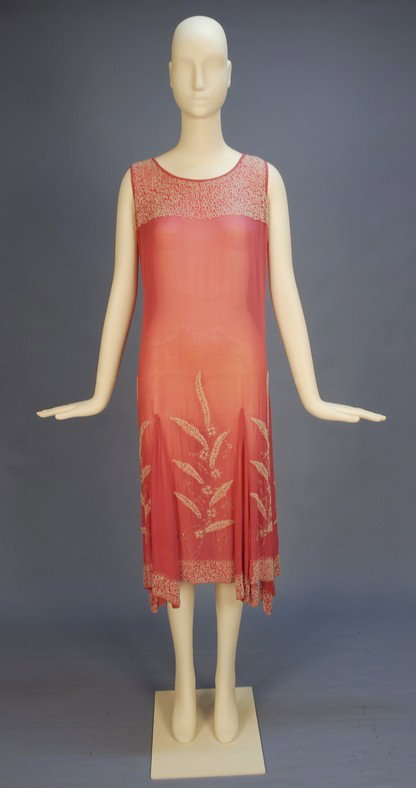 DECO BEADED CHIFFON DRESS. Sleeveless bubblegum pi: DECO BEADED CHIFFON DRESS. Sleeveless bubblegum pink with six skirt gores extending below the hem, the yoke and hem decorated with white beads in a dense serpentine pattern, the skirt panels decorated