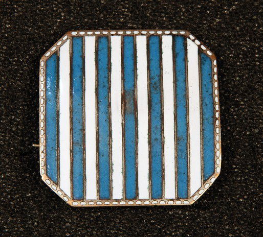 A WIENER WERKSTATTE ENAMELED BROOCH, c. 1910. Of c: A WIENER WERKSTATTE ENAMELED BROOCH, c. 1910. Of chamfered square form having vertical blue and white stripes with narrow border of white pellet shapes. Marked with "WW" and with Wiener Werkstatte ros