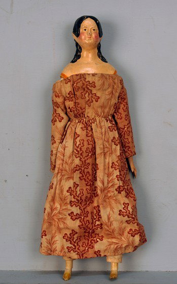 PAPIER MACHE MILLINER'S MODEL DOLL, 1840's. Should: PAPIER MACHE MILLINER'S MODEL DOLL, 1840's. Shoulder head doll with molded sausage curls, leather body with wooden arms and legs, period roller printed cotton dress. Height 13. (Crack to mache on shou
