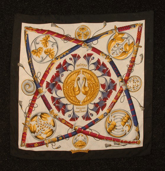 HERMES PRINTED SILK TWILL "DAIMYO" SCARF. Having a: HERMES PRINTED SILK TWILL "DAIMYO" SCARF. Having a white twill ground with woven pattern of ginkgo leaves, printed in reds, blues and golds with samurai swords and floral medallions, center medallion 