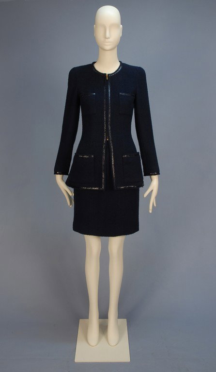 LADY'S CHANEL BOUTIQUE COTTON BLEND SUIT with PATE: LADY'S CHANEL BOUTIQUE COTTON BLEND SUIT with PATENT TRIM. Navy nubby weave collarless long jacket with zip front and zip side vents, four patch pockets, patent flat braided trim, sleeve having six gl