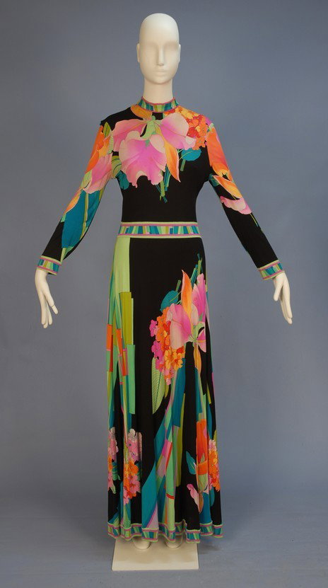 LEONARD PRINTED SILK JERSEY KNIT MAXI DRESS, c. 19: LEONARD PRINTED SILK JERSEY KNIT MAXI DRESS, c. 1970. Long sleeve with large scale tropical flowers and geometric design in hot hues on black, the stand collar, waist, hem and sleeve having a banded p