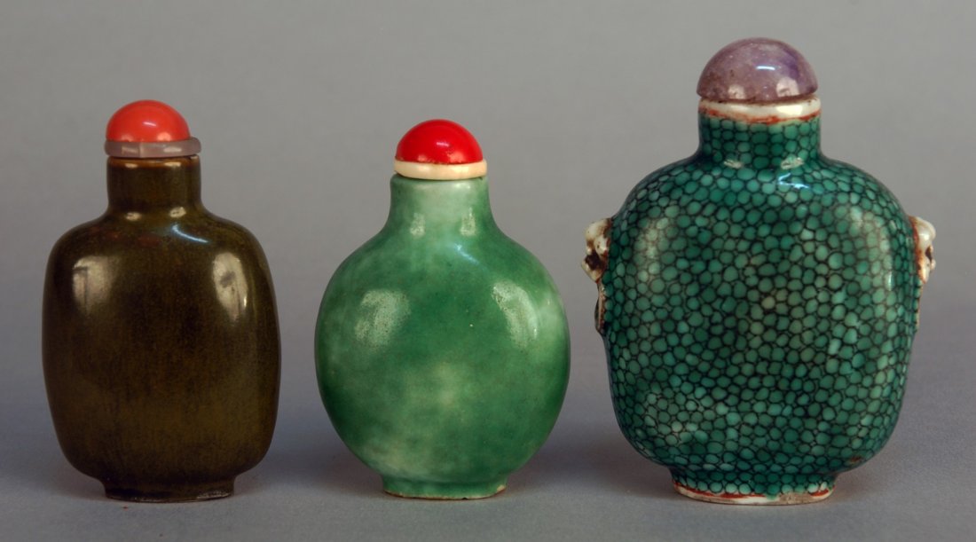 THREE CHINESE PORCELAIN SNUFF BOTTLES, 19th C. One: THREE CHINESE PORCELAIN SNUFF BOTTLES, 19th C. One green fish scale glaze with molded handles. One green jade colored monochrome. One tea dust monochrome. Excellent.