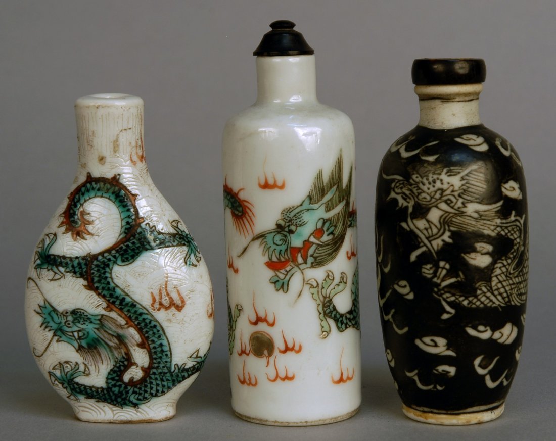 THREE CHINESE PORCELAIN SNUFF BOTTLES, 19th C. All : THREE CHINESE PORCELAIN SNUFF BOTTLES, 19th C. All decorated with dragon: One shouldered bottle with polychrome on white, one flattened flask incised and polychrome on white, one with thick black glaz