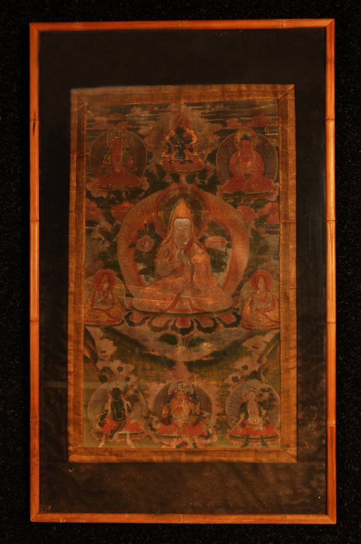 TIBETIAN THANGKA, 18th C. Framed gouache painting: TIBETIAN THANGKA, 18th C. Framed gouache painting on canvas of Sakymuni Buddha trimmed in silk brocade. 23 1/2 x 13 1/4 sight. (1/4 inch hole upper right) otherwise very good.