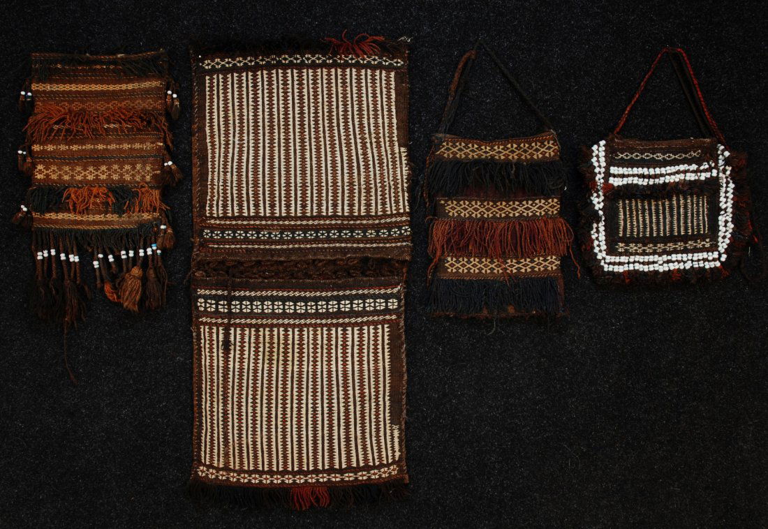 FOUR BALUCHISTAN FRINGED WOOL BAGS, MID 20th C. Al: FOUR BALUCHISTAN FRINGED WOOL BAGS, MID 20th C. All in earth tones, consisting of pair of saddle bags, 42 x 20. Two having white beads: One 13 x 16 and one 12 1/2 x 24. One 17 x 12. Good-excellent.