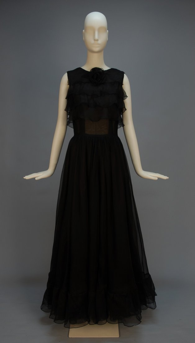 BOHAN for DIOR COUTURE EVENING DRESS, SPRING-SUMME: BOHAN for DIOR COUTURE EVENING DRESS, SPRING-SUMMER 1963. Sleeveless black silk organza with four wide bodice ruffles and self flower at neck, full skirt of three layers, the outer with deep hem ruffl