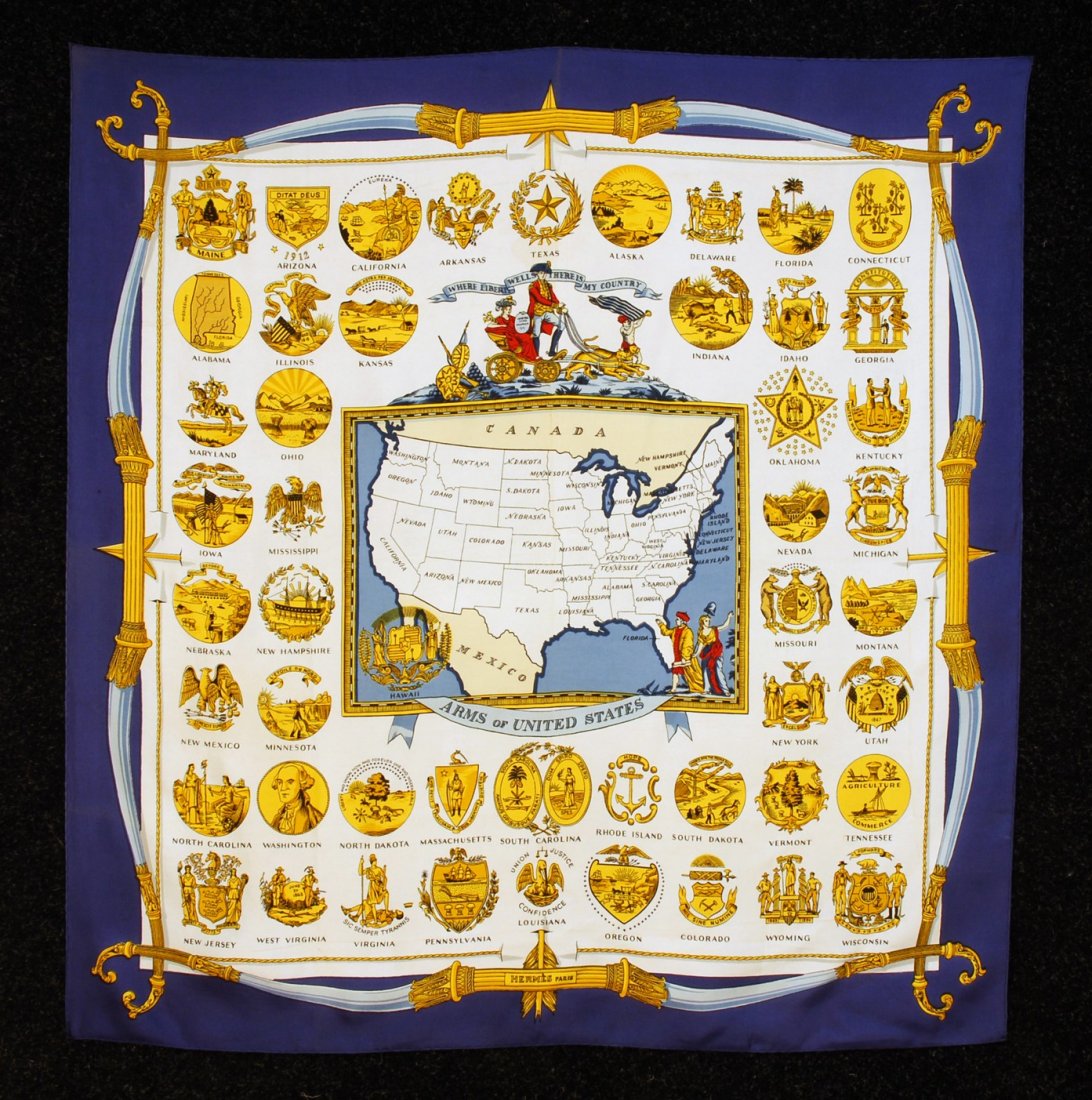 HERMES PRINTED SILK TWILL "ARMS of UNITED STATES": HERMES PRINTED SILK TWILL "ARMS of UNITED STATES" SCARF, 1955 DESIGN. Gold, red and blue map and state seals, with a bow and arrow border. "Hermes-Paris" within design. 35 x 33 3/4. (Slightly faded al