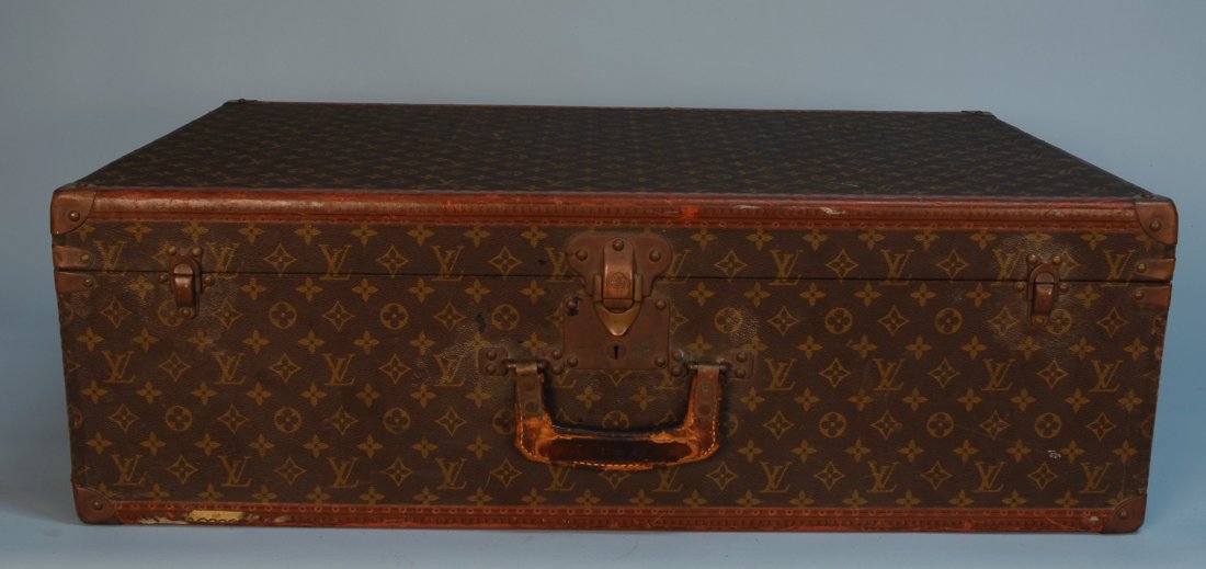 A VINTAGE LOUIS VUITTON HARD SUITCASE. Partial lea: A VINTAGE LOUIS VUITTON HARD SUITCASE. Partial leather trim and brass corners with "LV" stenciled logo surface. 31 x 21 x 10. (Bottom of case torn and repaired, no keys) fair. Together with a Louis Vu