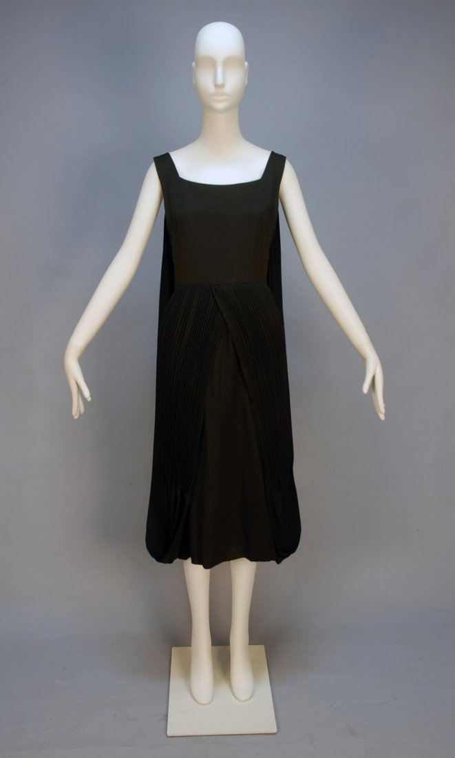 UNUSUAL HELENA BARBIERI SILK DRESS, 1960's. Sleeve: UNUSUAL HELENA BARBIERI SILK DRESS, 1960's. Sleeveless black faille with fitted bodice and pencil skirt having a long over skirt crossed at the waist with open front pleated to the knee, fabric forms 
