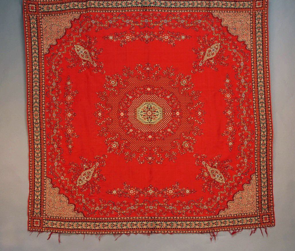 FRENCH WOOL TABLE COVER, 19th C.: Red square decorated with a stylized floral in orange, blue, black and cream, having central medallion and elaborate corner design. 56 x 58. SM. (Scattered tiny holes) good.