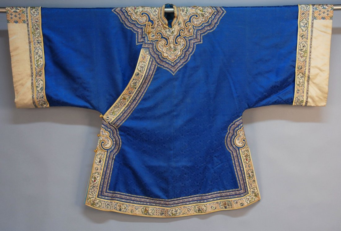 CHINESE SILK EMBROIDERED TUNIC, c. 1900.: Cobalt on cobalt silk brocaded with clouds and bats having elaborate applied ivory satin cloud collar with silk and gold metallic figural embroidery and brocade bands, matching trim along the diagonal