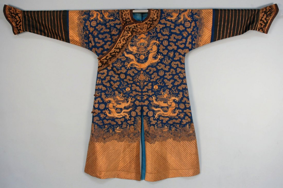CHINESE EMBROIDERED DRAGON ROBE, 19th C.: Blue silk nine dragon robe worked entirely in metallic and couched metallic embroidery. Unusually deep wavy "li shui" in variagated gold tone threads. Very large size. 86 x 56. (A few loose couched th
