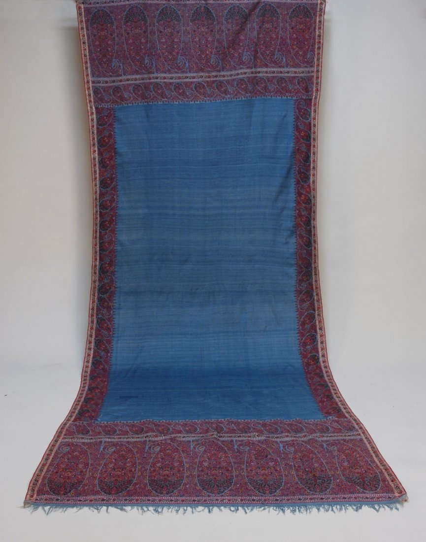 HANDMADE KASHMIR PAISLEY SHAWL, 19th C.: Blue wool long shawl having red, orange, yellow, cream and green paisley border, deep end borders with large botehs, signed. 53 x 116. SM. (One minor hole) excellent.