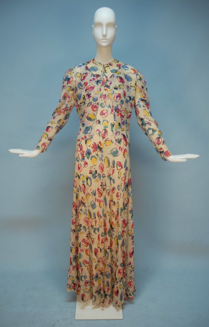 PRINTED CHIFFON HALTER DRESS and JACKET, 1930's.: Long bias cut gown in cream printed with colorful abstract flowers having topstitched pointed collar and deep back slit, matching jacket gathered at the shoulder, single hook & eye closure. B-36, W-28