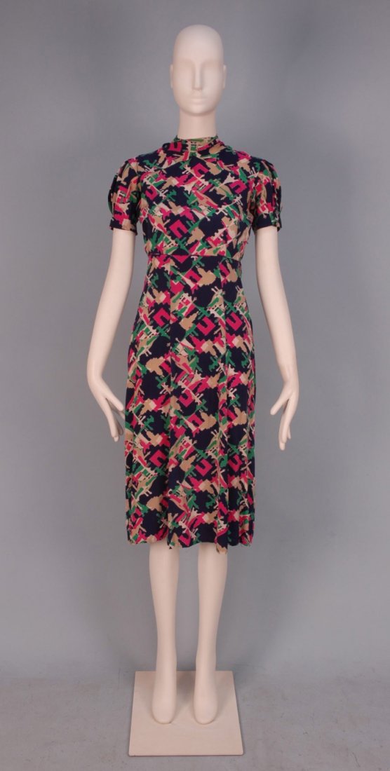 SCHIAPARELLI FABRIC DRESS, c. 1940.: Homemade day dress sewn with Schiaparelli's printed silk "Paris Exposition 1937" fabric depicting silhouettes of various landmarks including the Eiffel Tower and Arc de Triomphe in green, fuchsia, cre