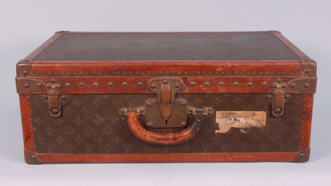 LOUIS VUITTON HARD CASE, EARLY 20th C.: Small logo stenciled case trimmed in brass studded brown leather having a linear "LV" repeat, brass corners, clasps marked "LV", lock engraved "Louis Vuitton" with patent number, Paris and London addr